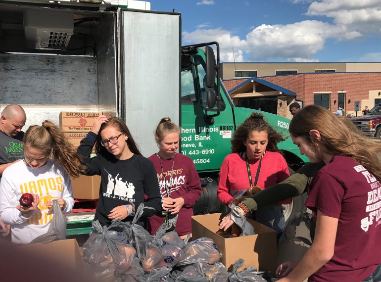 High school students volunteer at The Village Christian Church food truck in MInooka., Il to serve families struggling in the community.